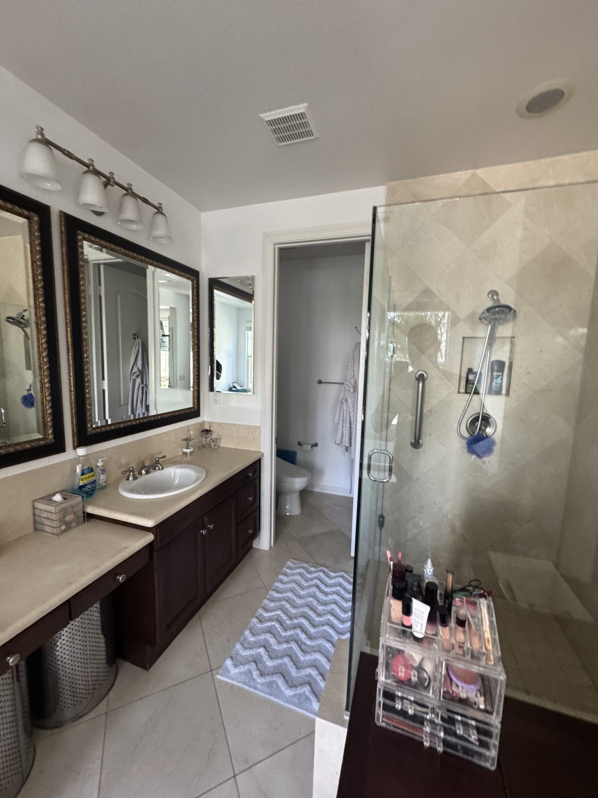 Dated master bathroom in Encinitas before the remodel, with beige tile and a dark wood vanity