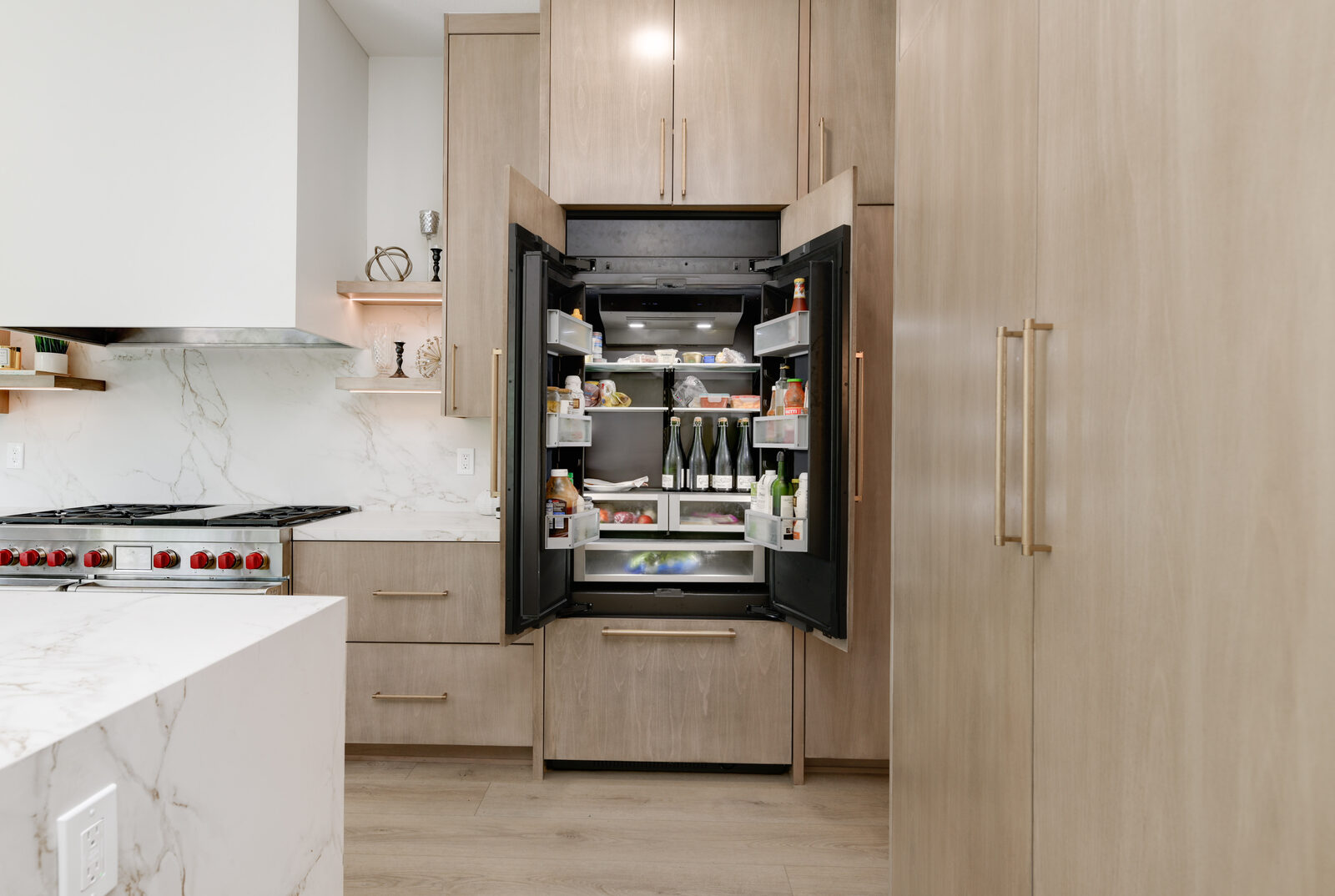 Integrated panel-front built-in refrigerator concealed in white-oak cabinetry