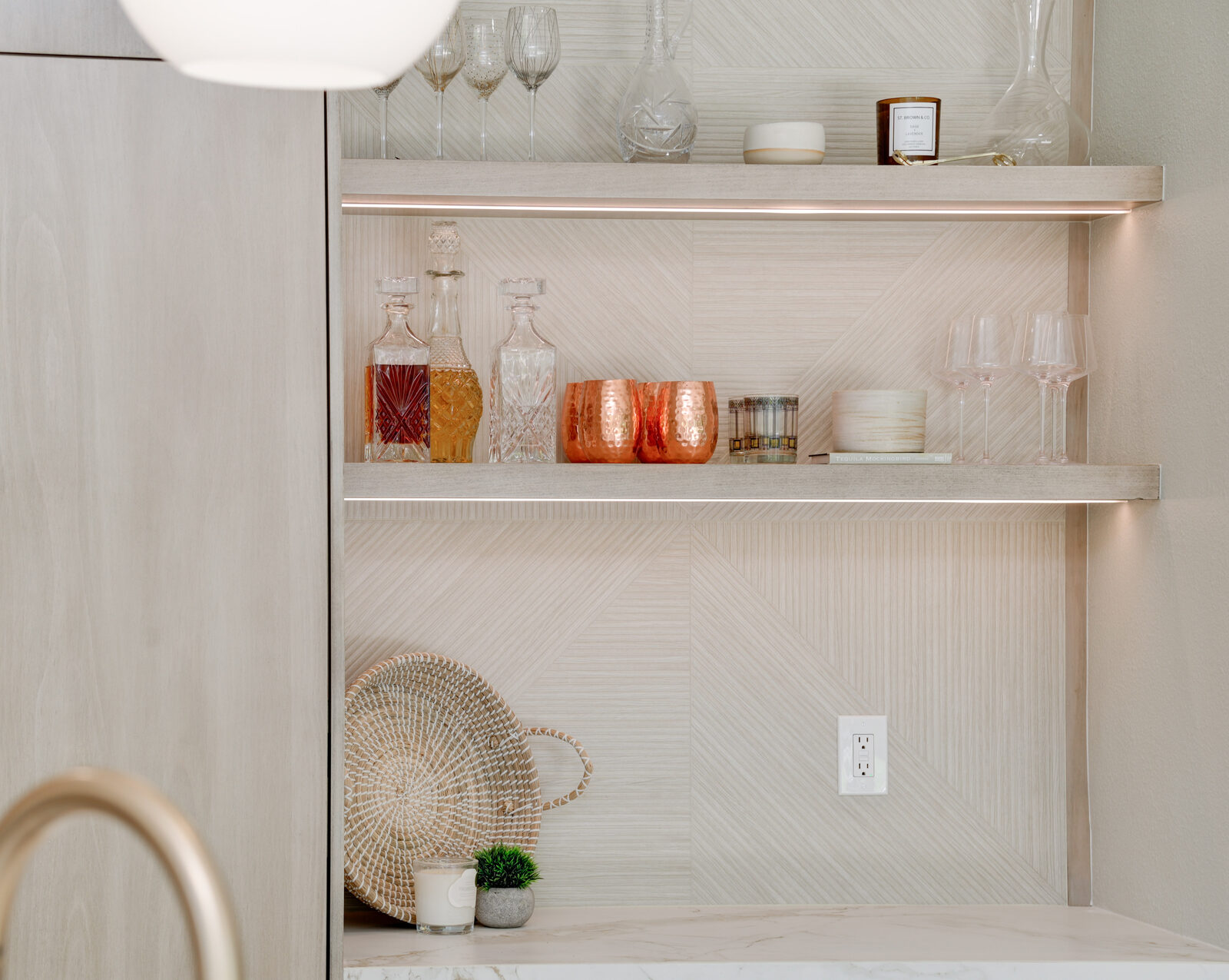 Styled bar nook with floating LED-lit shelves and a textured tile back panel