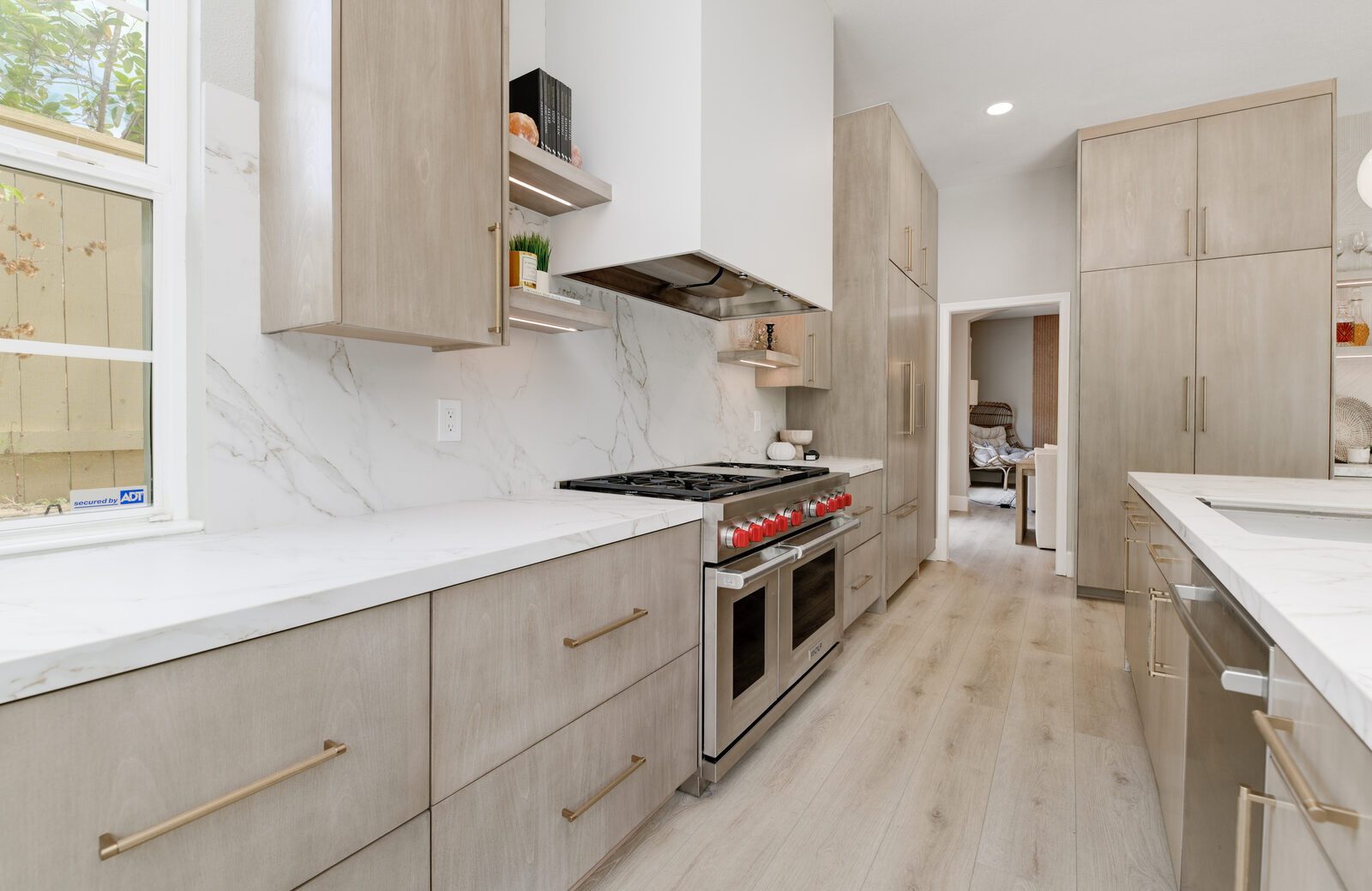 Professional gas range with a full-height slab marble-look backsplash and floating shelves